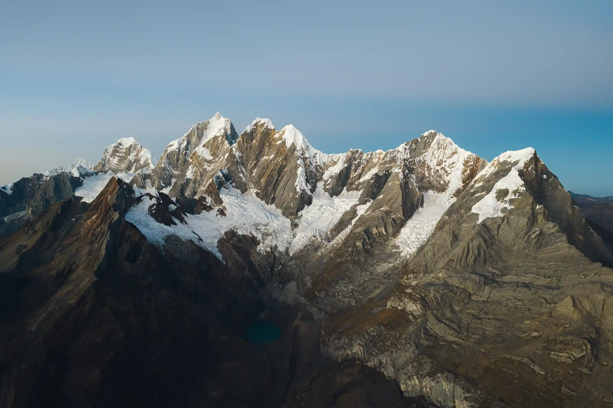 Aerial view along the line of jagged snow summits of Nevados Carnicero, Yerupajá, Yerupajá Chico, Jirishanca, Rondoy and Ninashanca, Cordillera Huayhuash, Peru